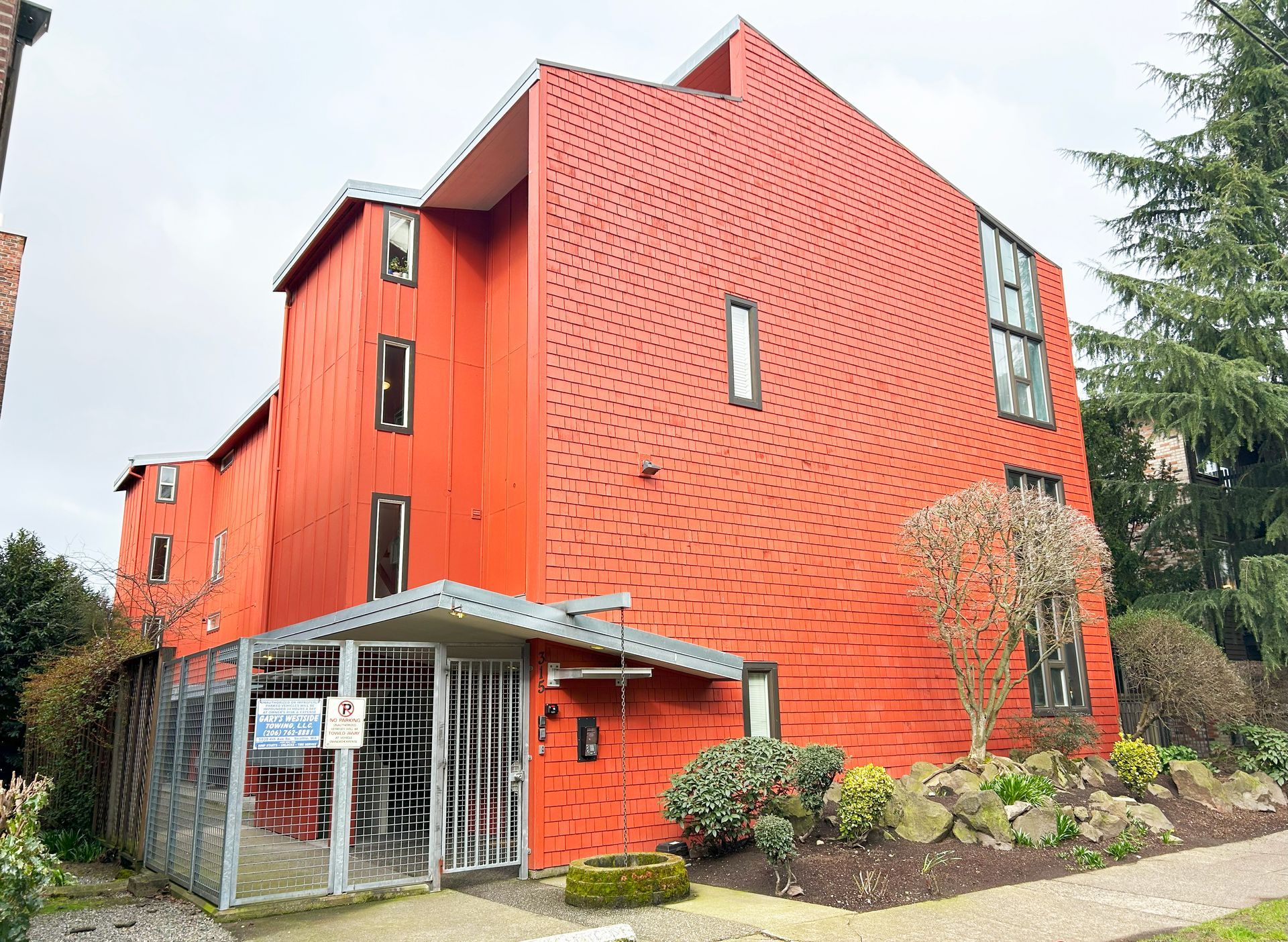 A large red building with a sign that says ' for sale ' on it