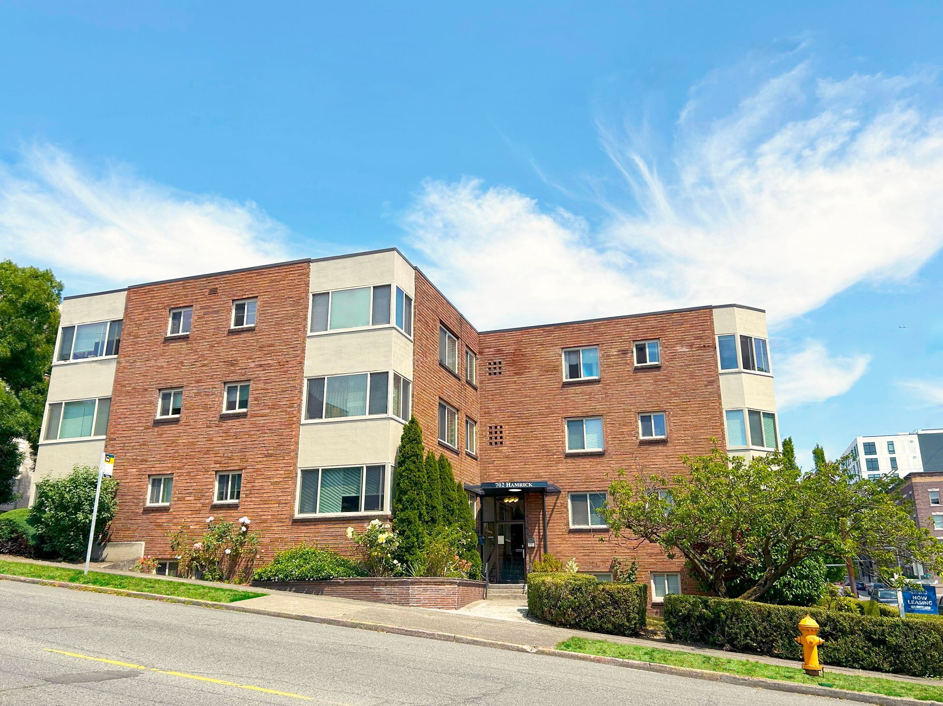 A large brick apartment building with a fire hydrant in front of it