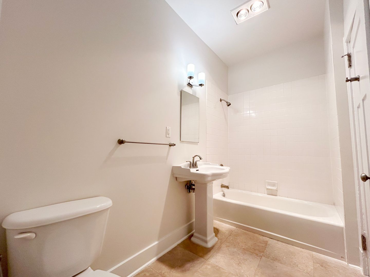 A bathroom with a toilet , sink , and bathtub.