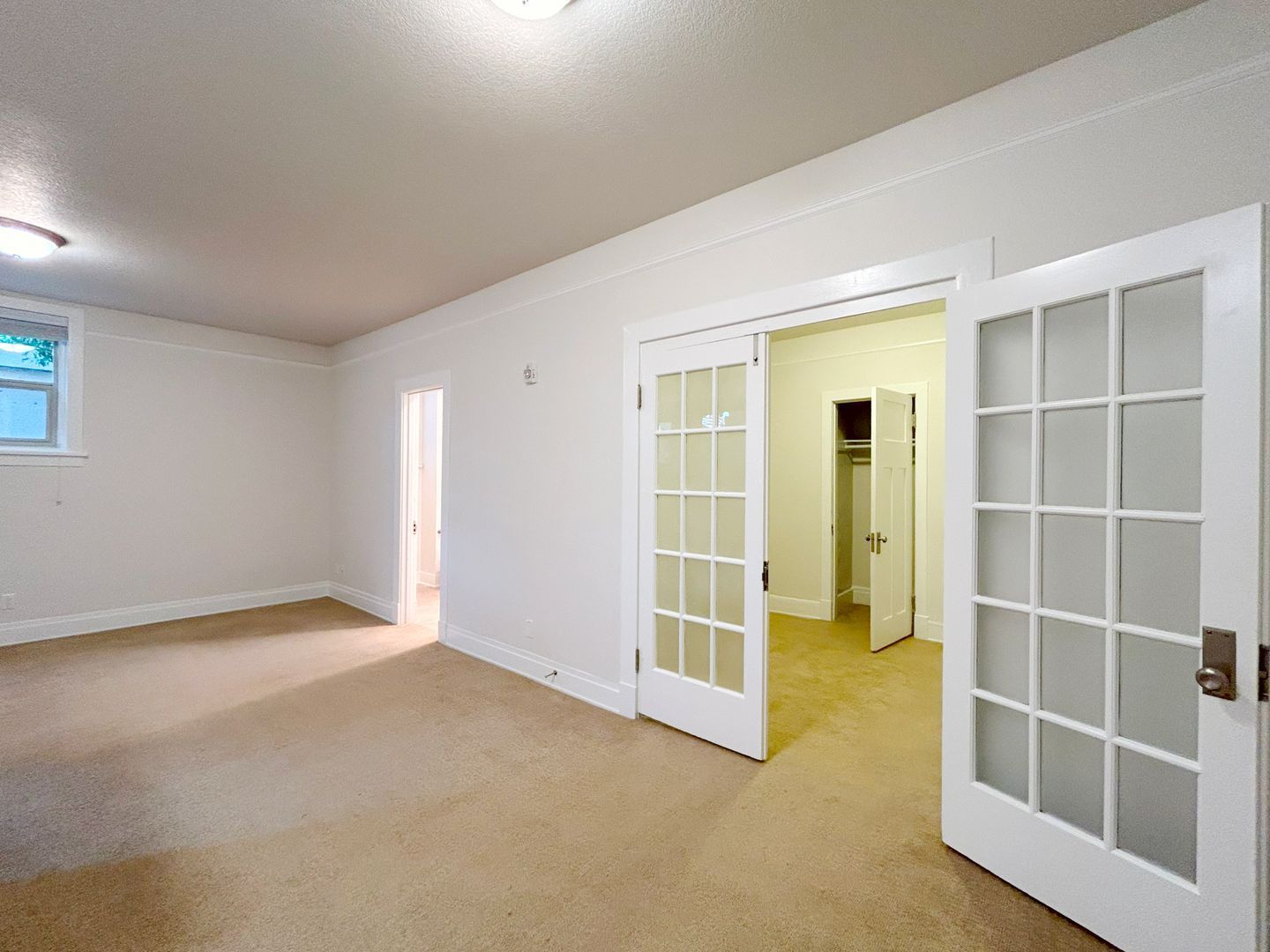 An empty room with sliding glass doors leading to a closet.