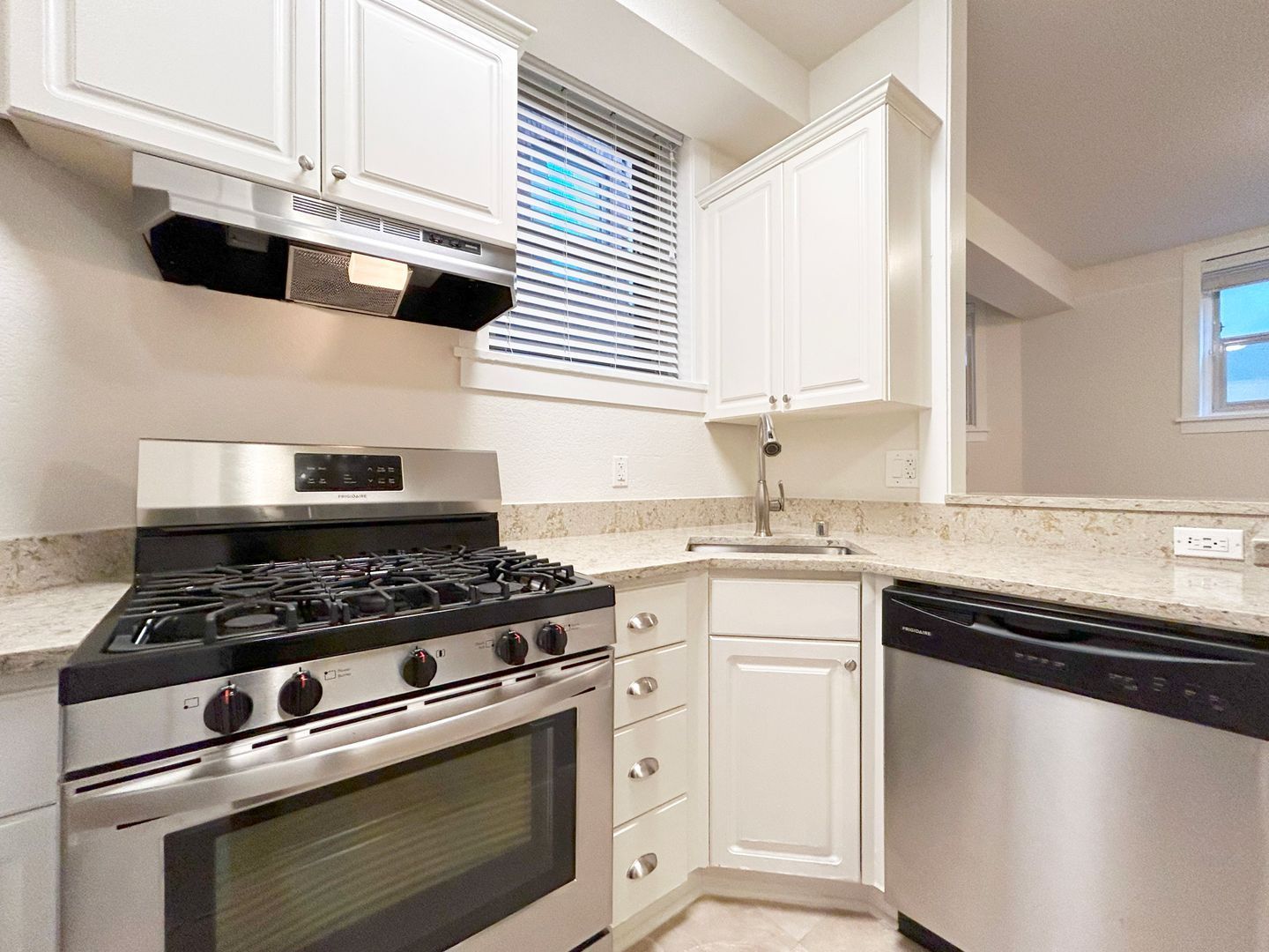 A kitchen with a stove , sink , and dishwasher.