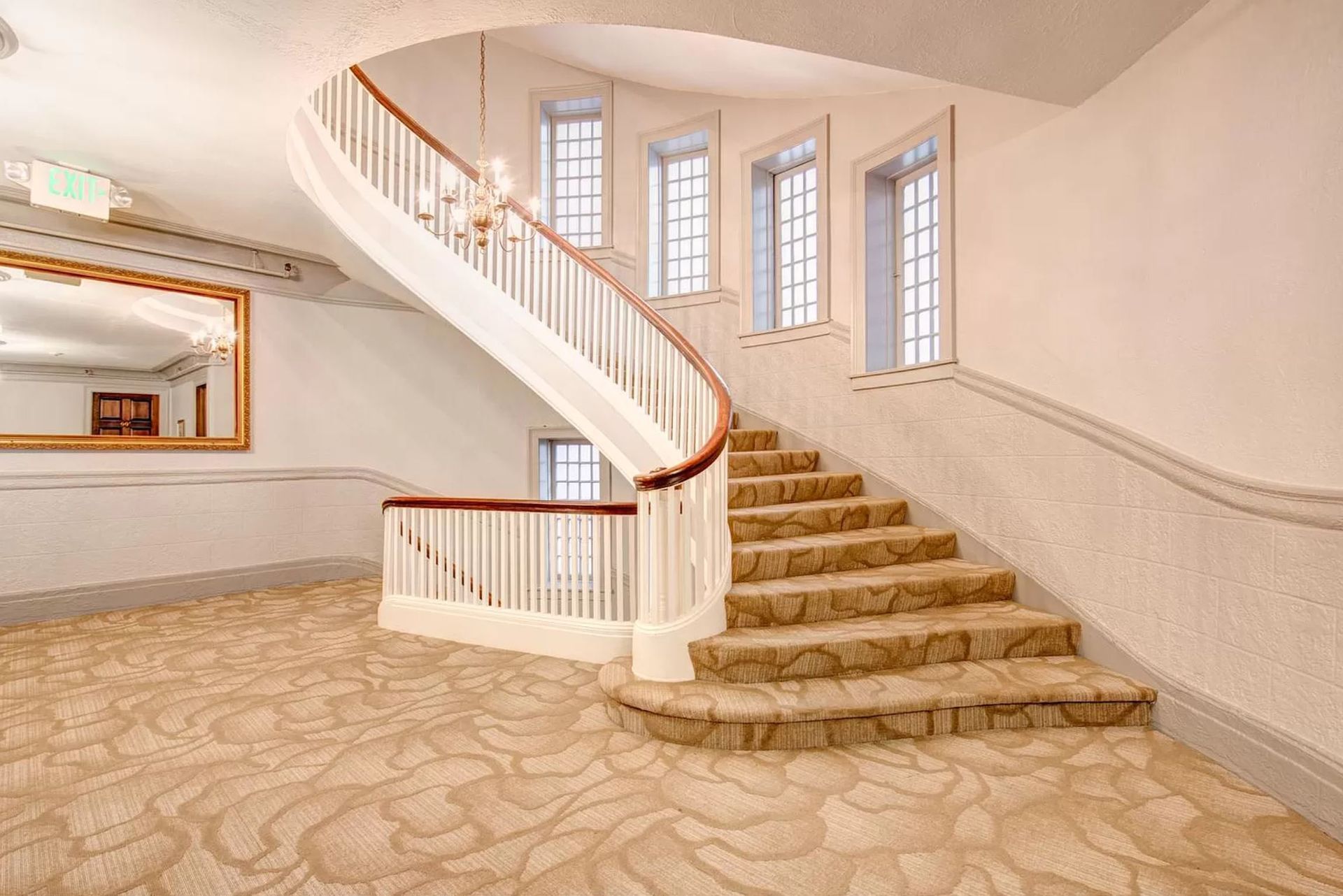 A curved staircase with a wooden railing in an empty room.