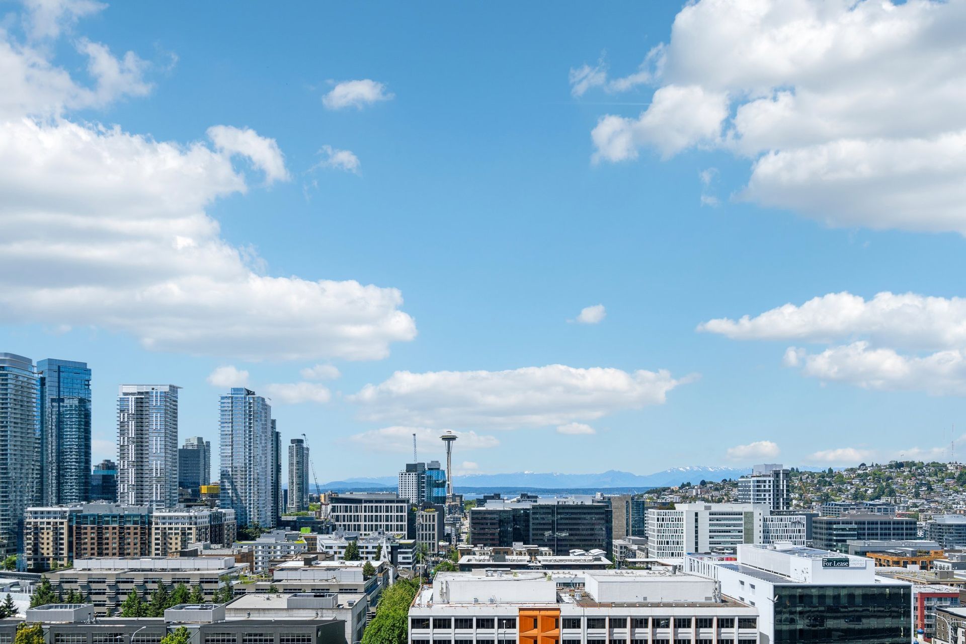 An aerial view of a city with a blue sky and clouds.