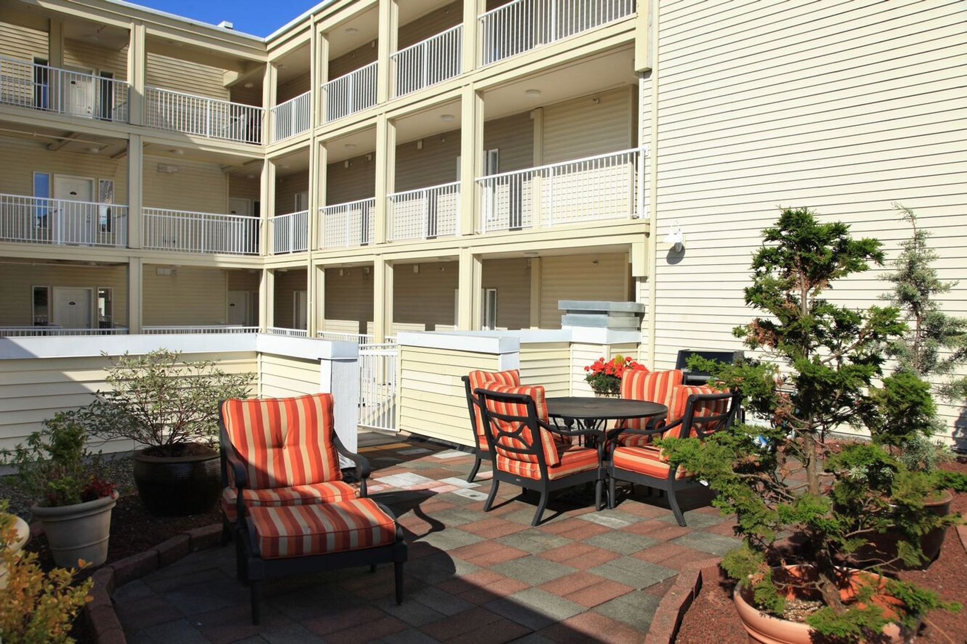 A patio with chairs and a table in front of a building