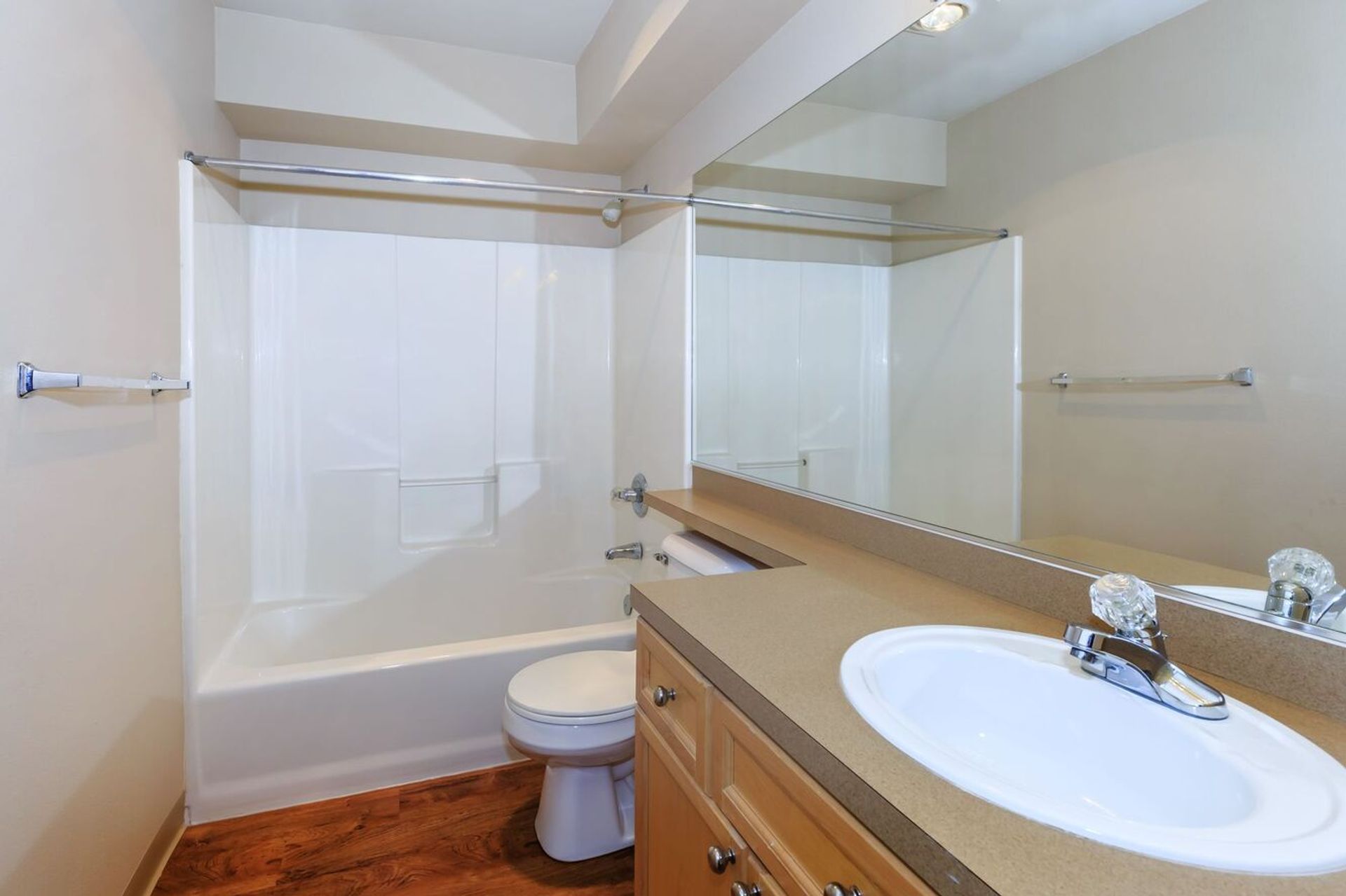 A bathroom with a sink , toilet , bathtub and mirror.