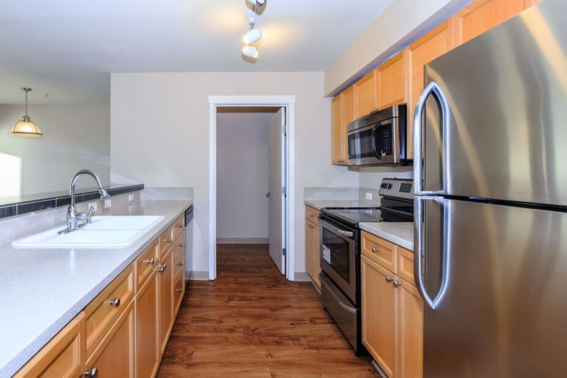 A kitchen with stainless steel appliances and wooden cabinets