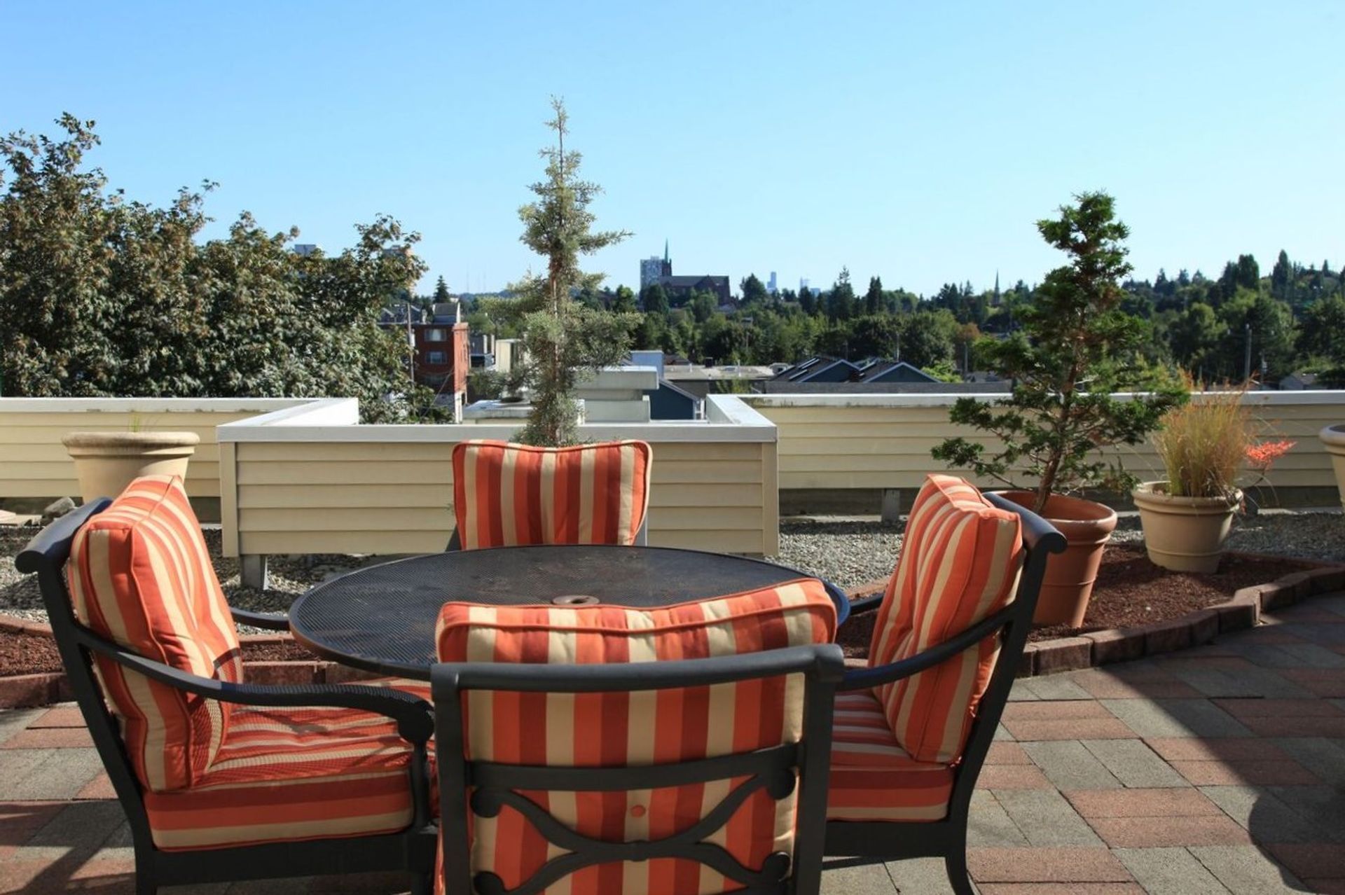 A table and chairs on a patio with trees in the background