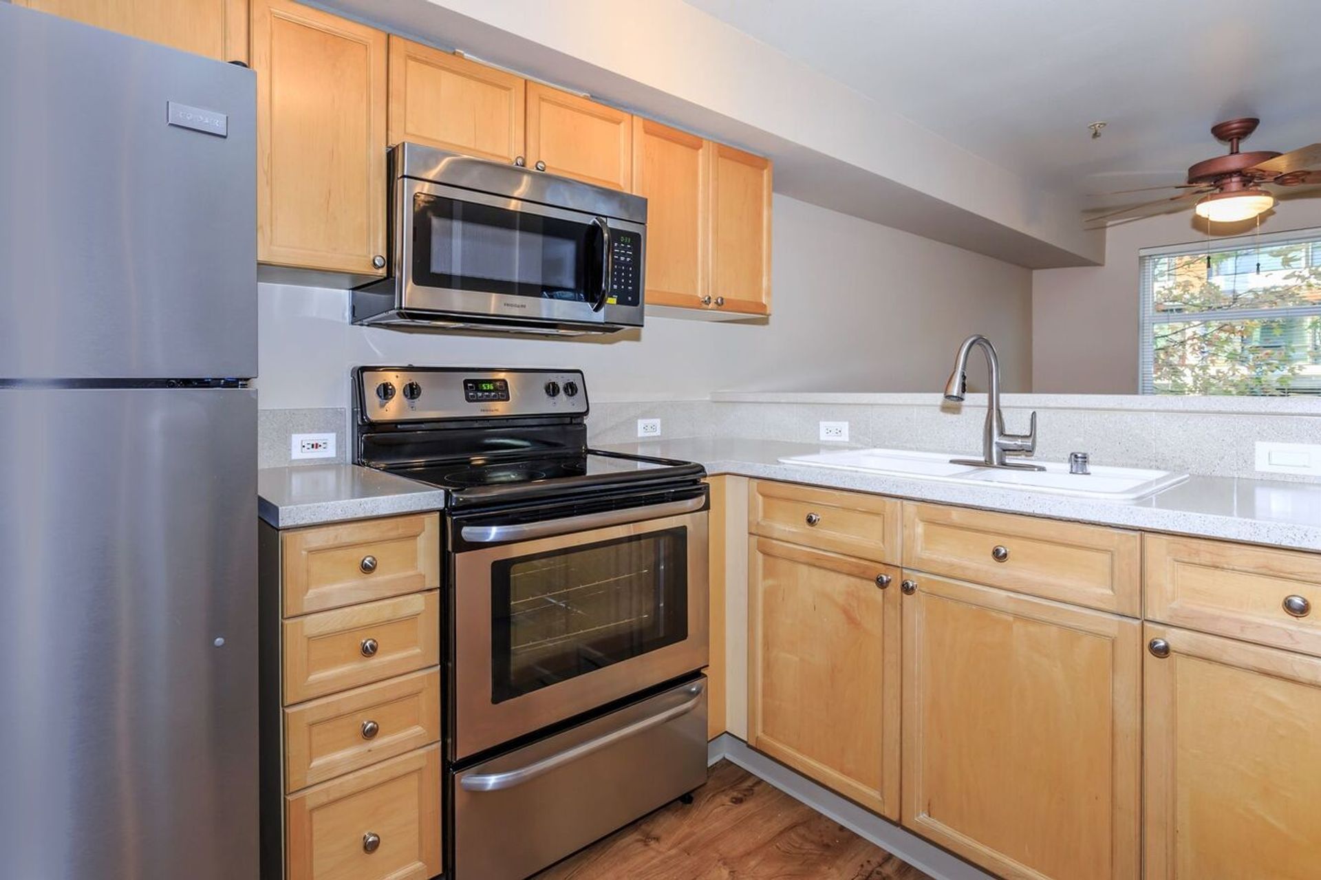 A kitchen with stainless steel appliances and wooden cabinets.