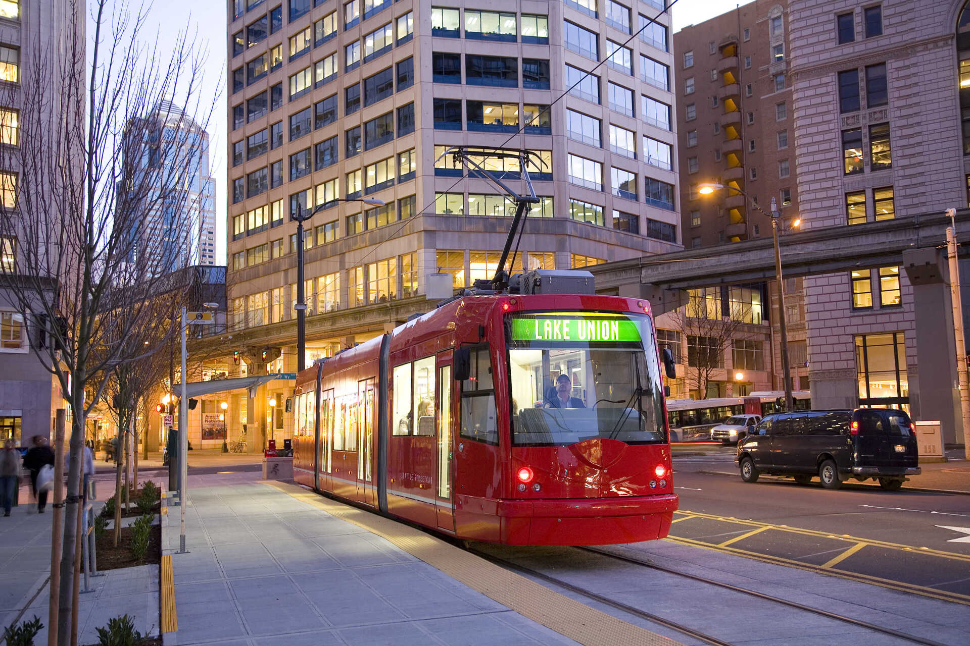 A red trolley is going down a city street
