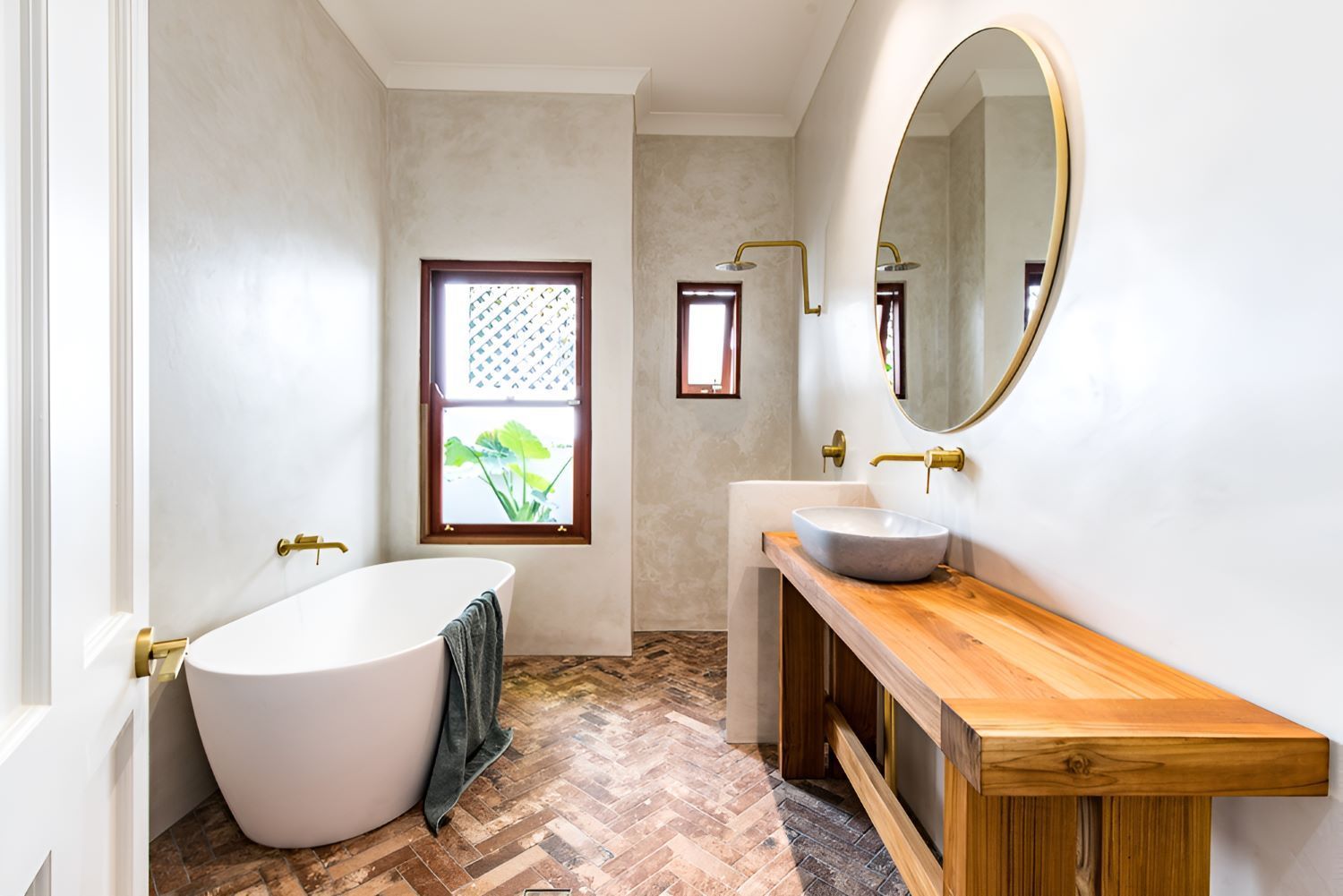 A Bathroom With A Bathtub And Round Mirror — Bananacoast Waterproofing in Korora, NSW