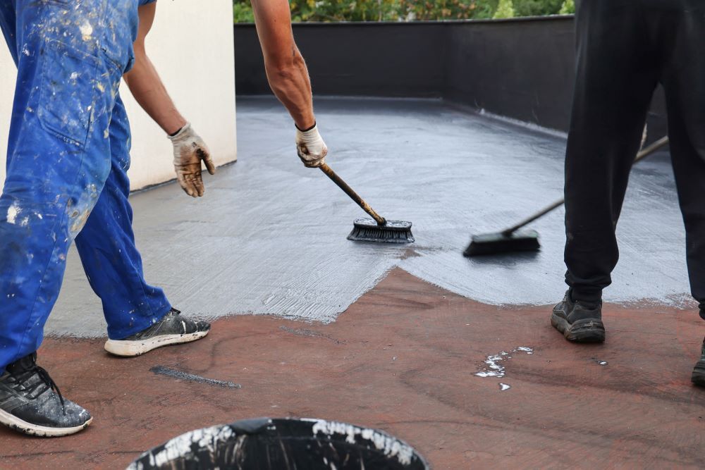 Two Construction Workers Applying Waterproofing In The Roof — Bananacoast Waterproofing in Korora, NSW
