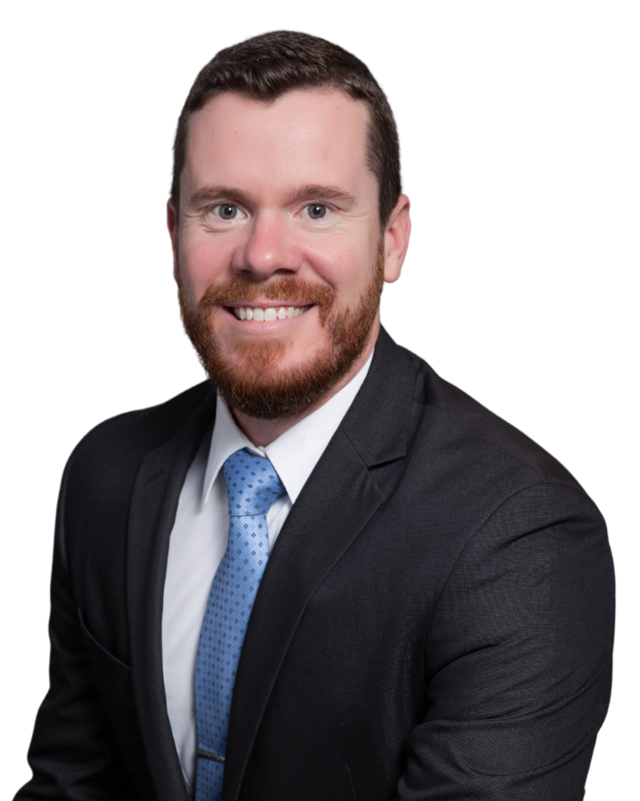 A man in a suit and tie is smiling for the camera