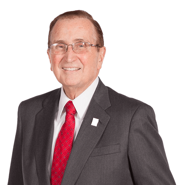 A man in a suit and tie is smiling for the camera