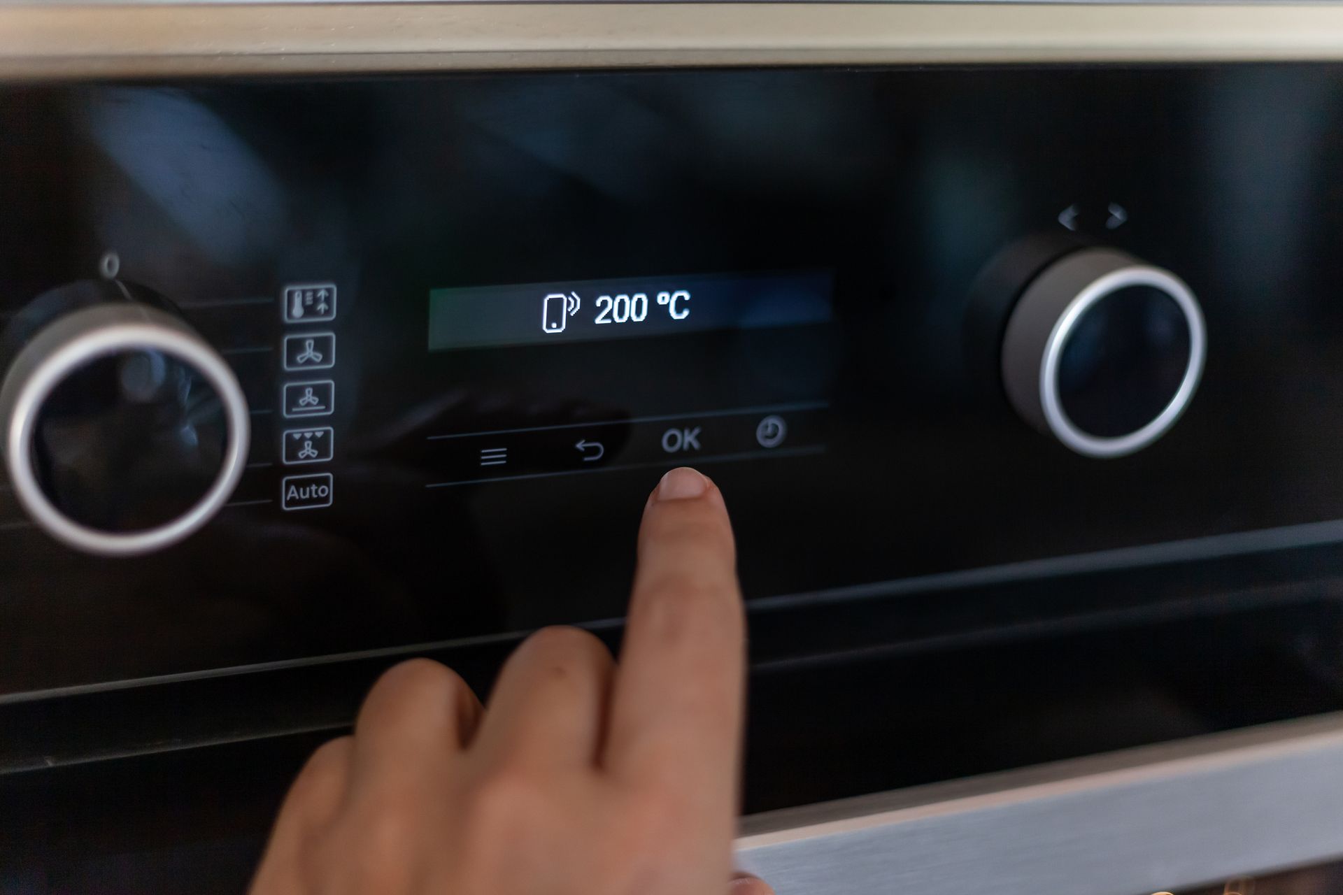 Un uomo sta riparando un frigorifero con un cacciavite.