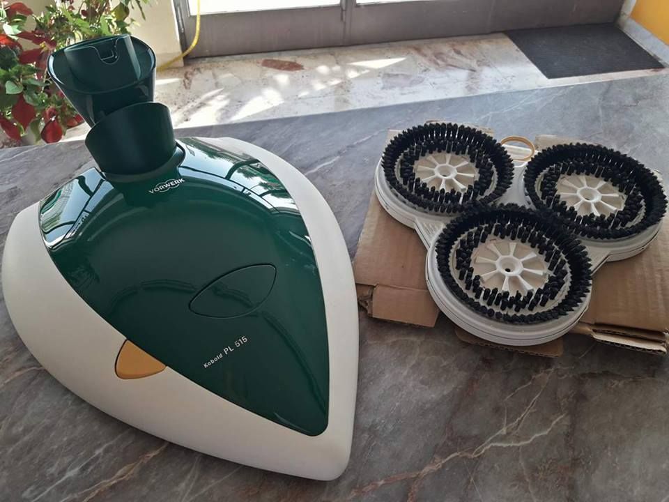 Un dispositivo di pulizia verde e bianco con tre spazzole su un tavolo