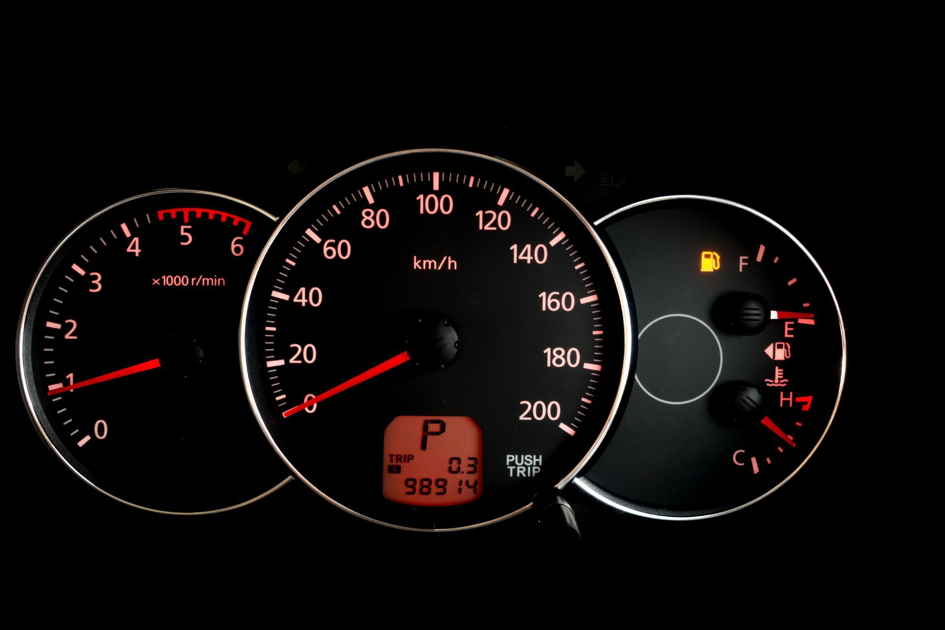 A man is working on a car with a pair of pliers.