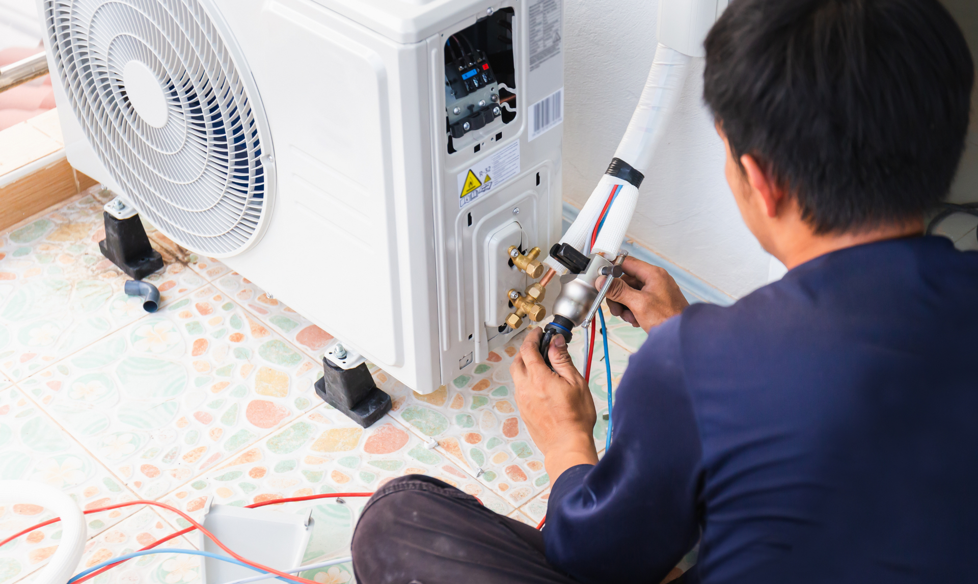 Person installing an AC unit outside.