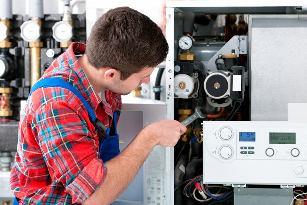 Man Fixing The Water Heater — Trusted Electricians in Nowra, NSW