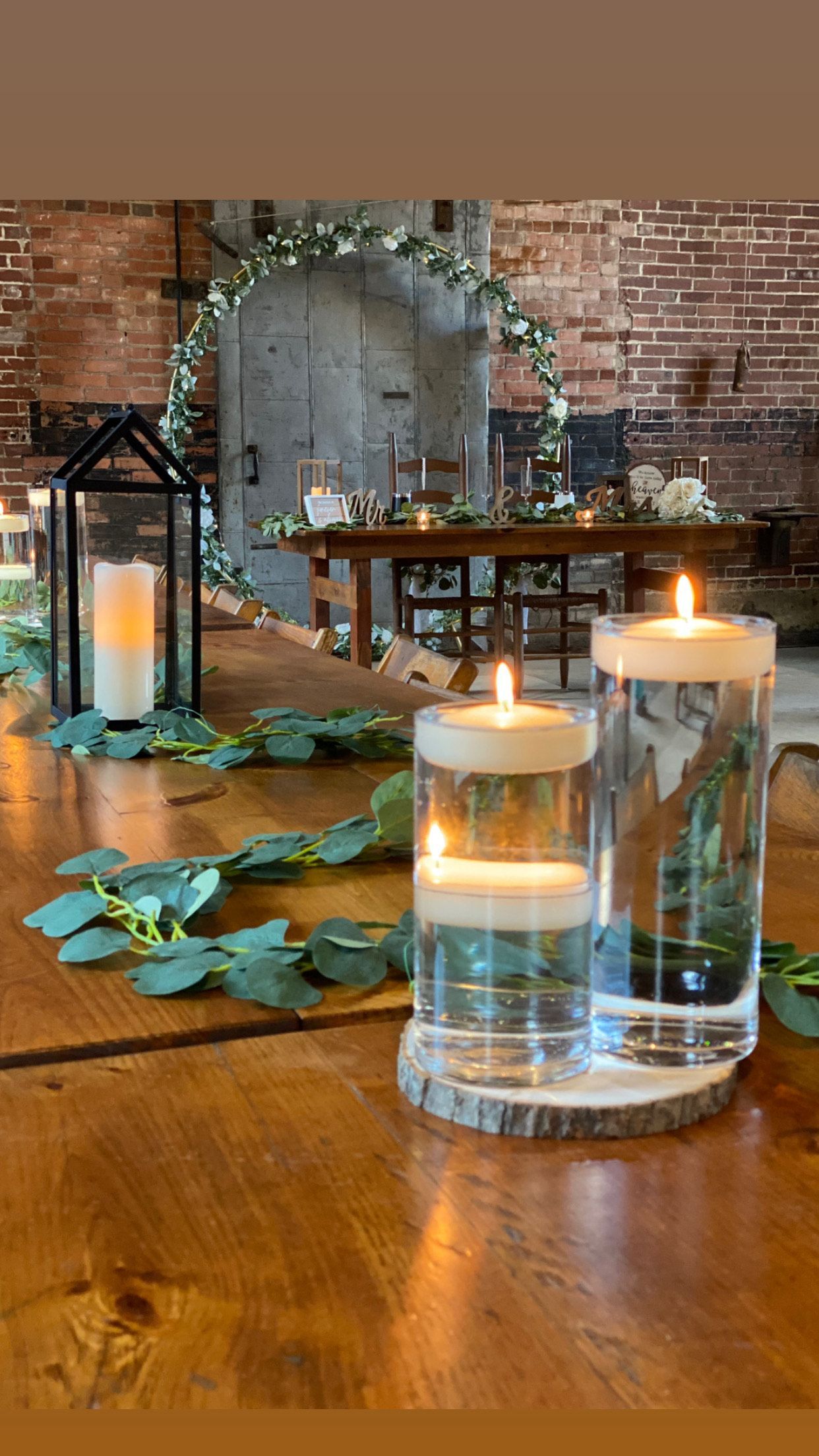 A wooden table with candles and lanterns on it.