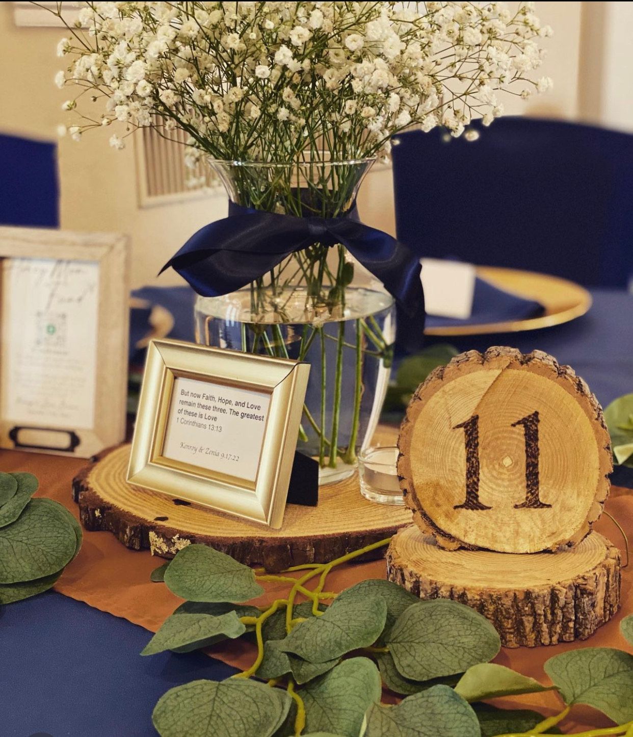 A table with a vase of baby 's breath and a wooden number 11