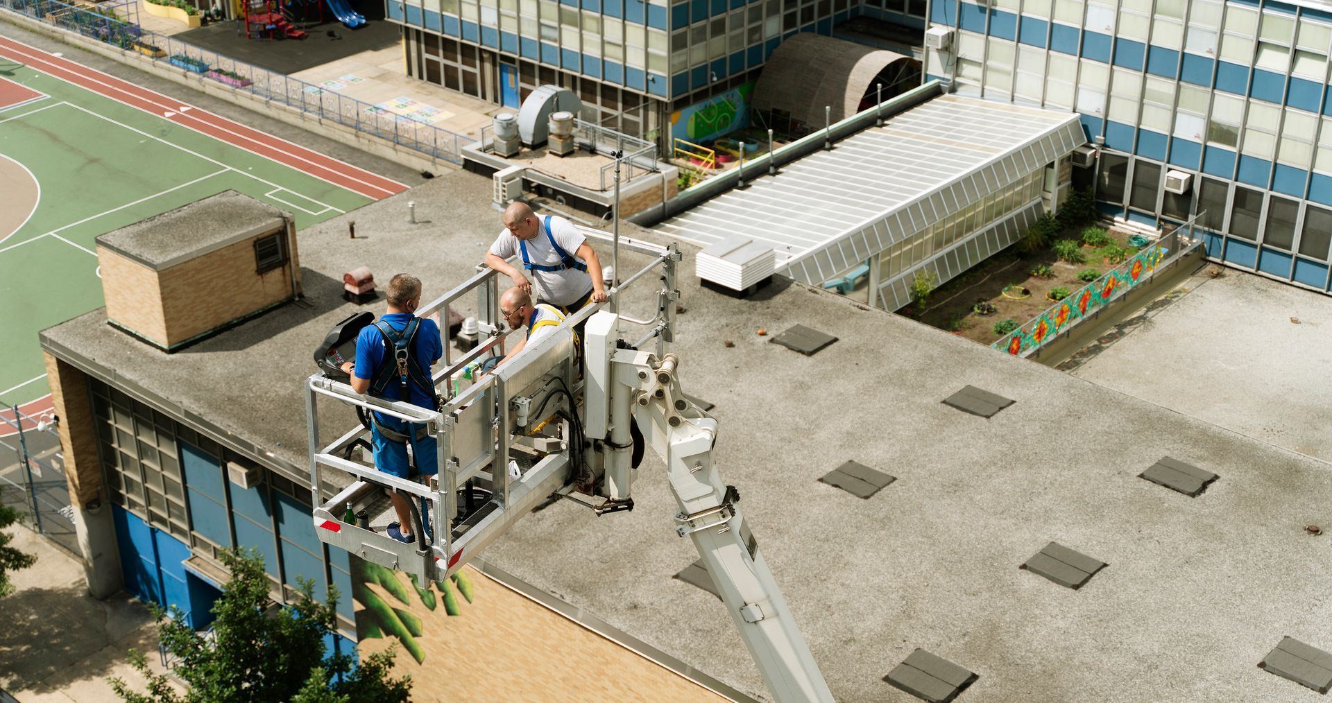 Two men are working on the roof of a building.