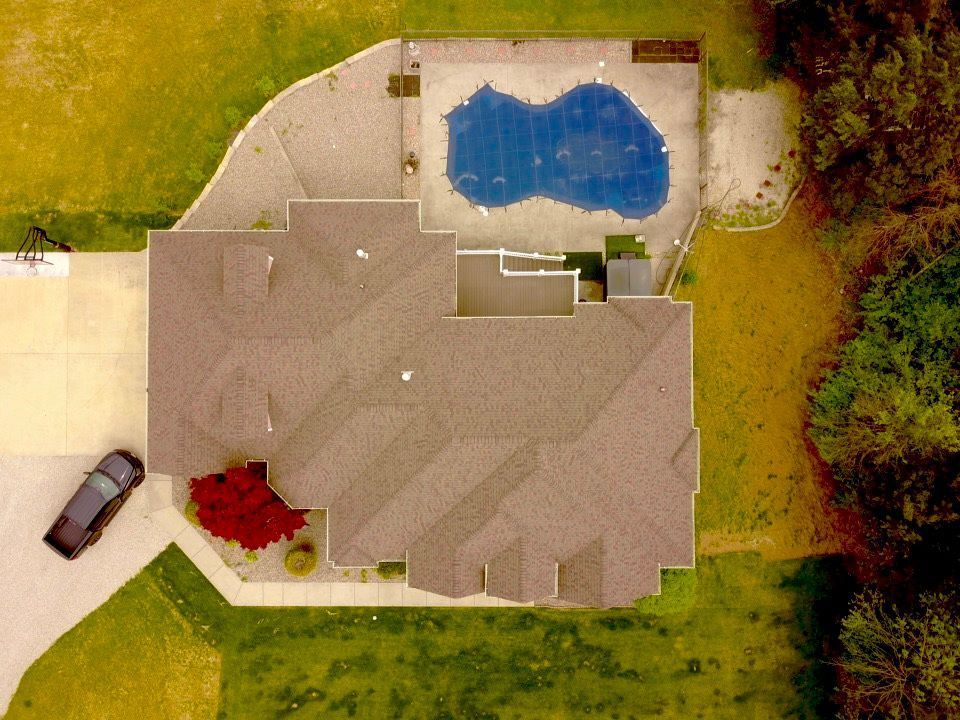 An aerial view of a house with a pool in the backyard