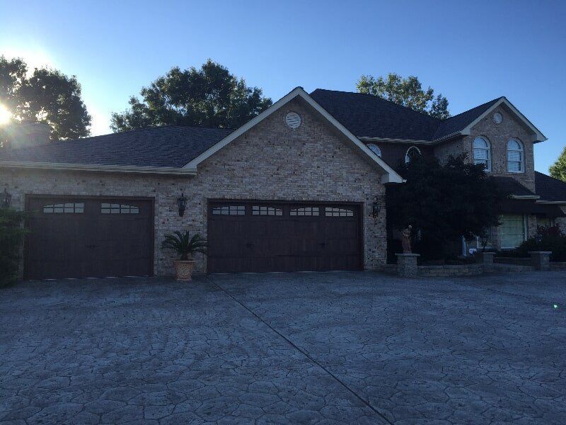 A large house with three garage doors and a driveway