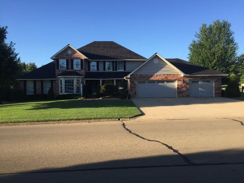 A large brick house with a black roof