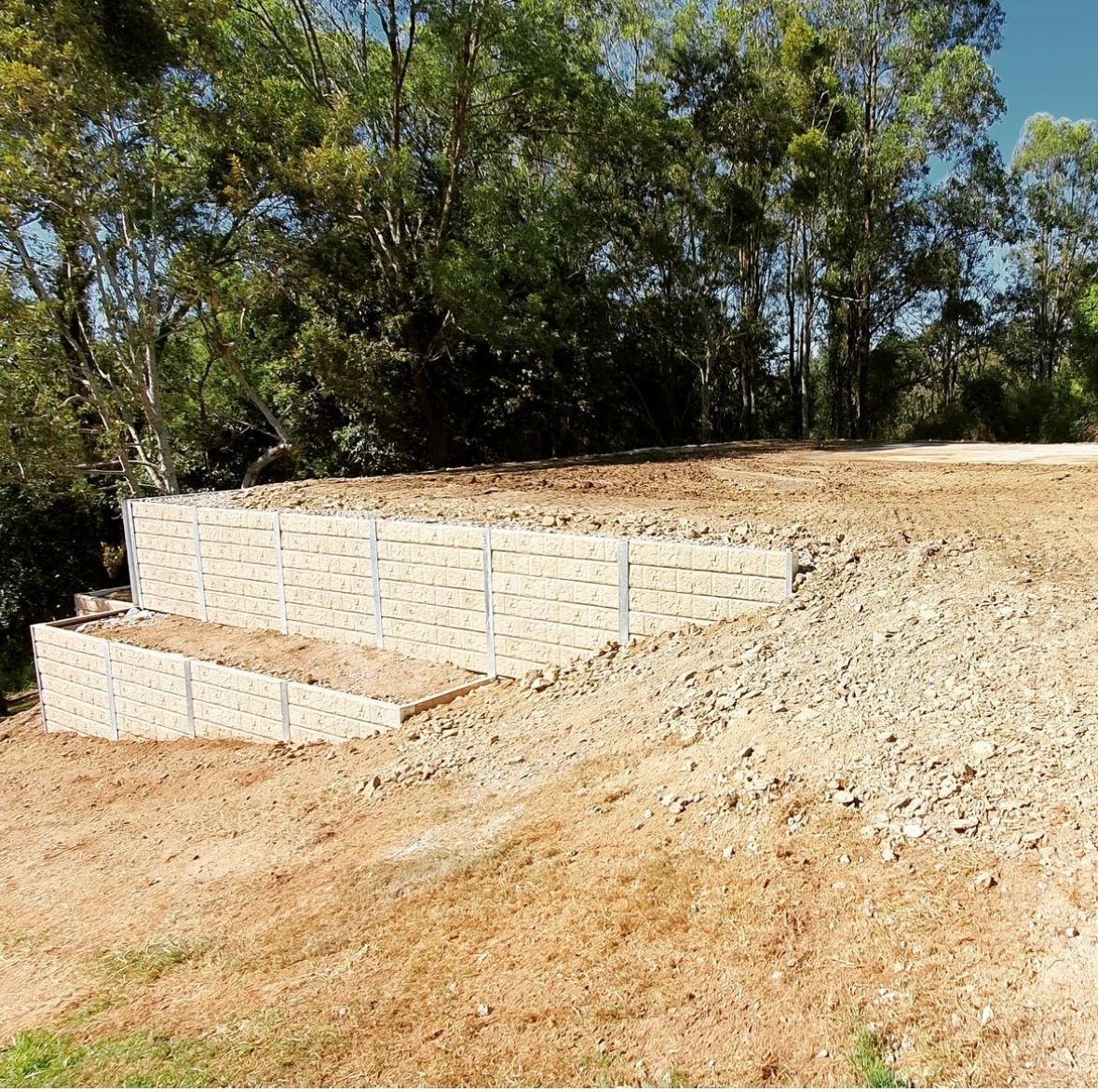 A wooden fence is sitting in the middle of a dirt field.