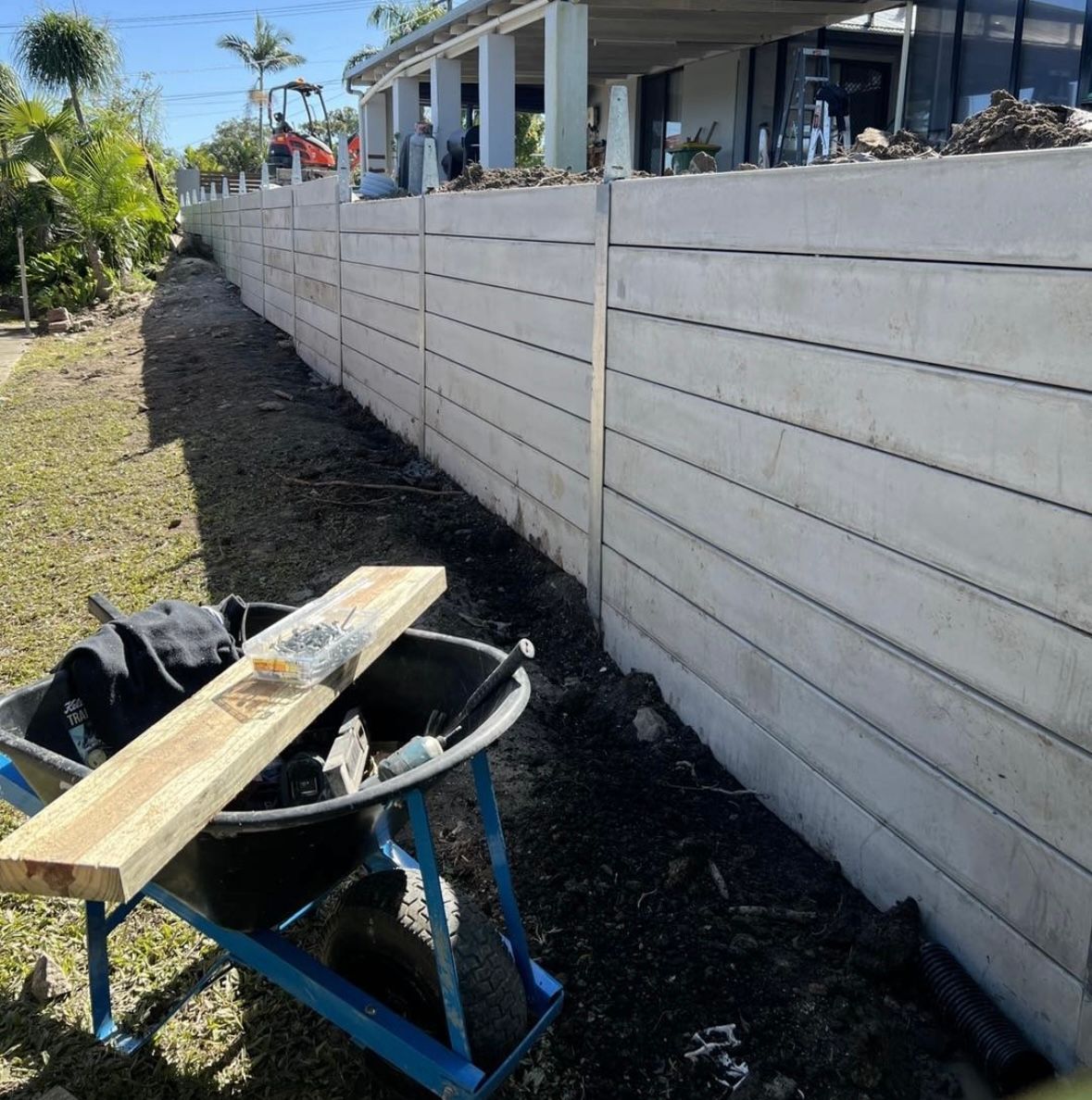 A concrete wall is being built on top of a dirt field.
