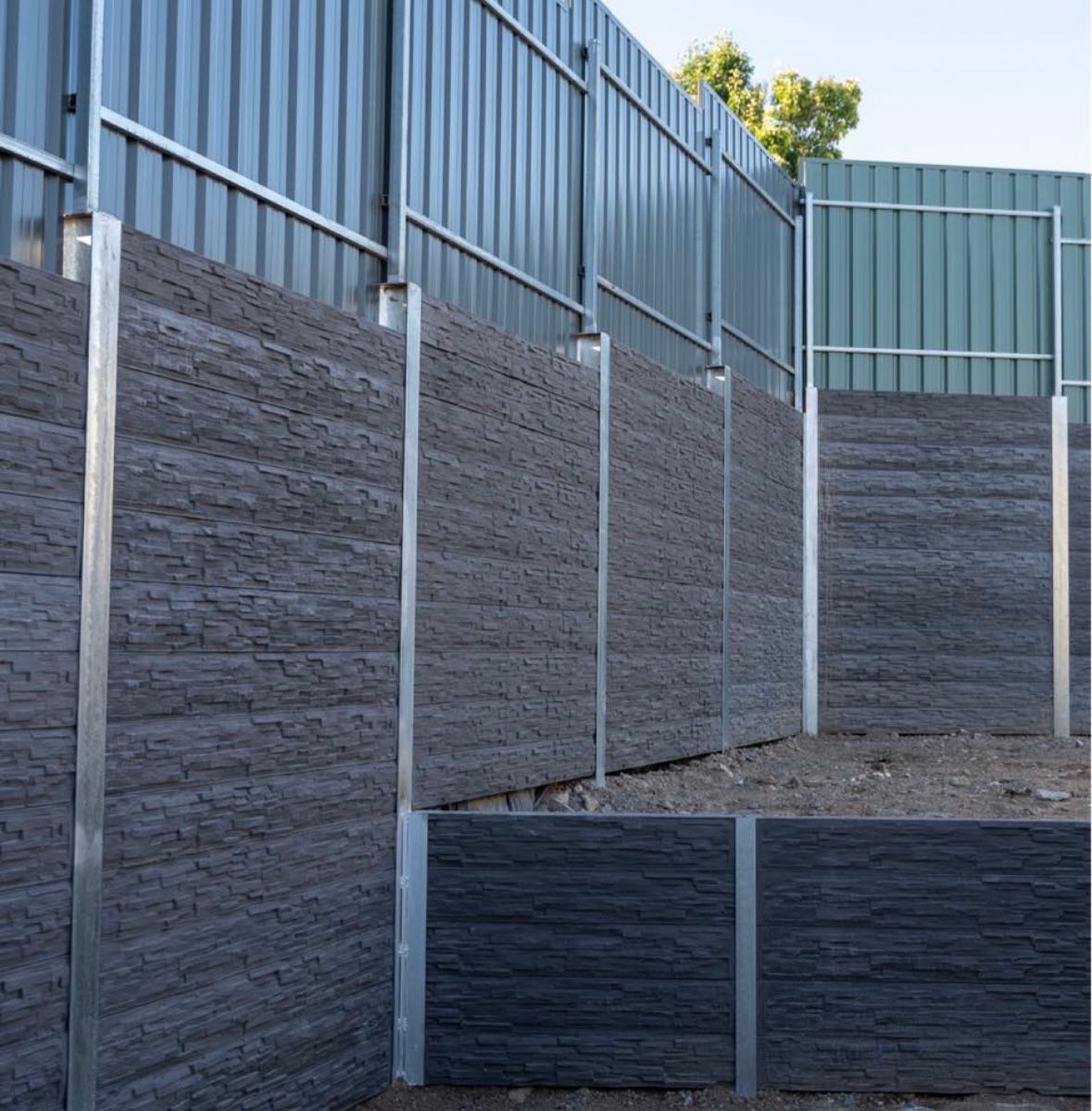 A fence is surrounded by a row of concrete walls.