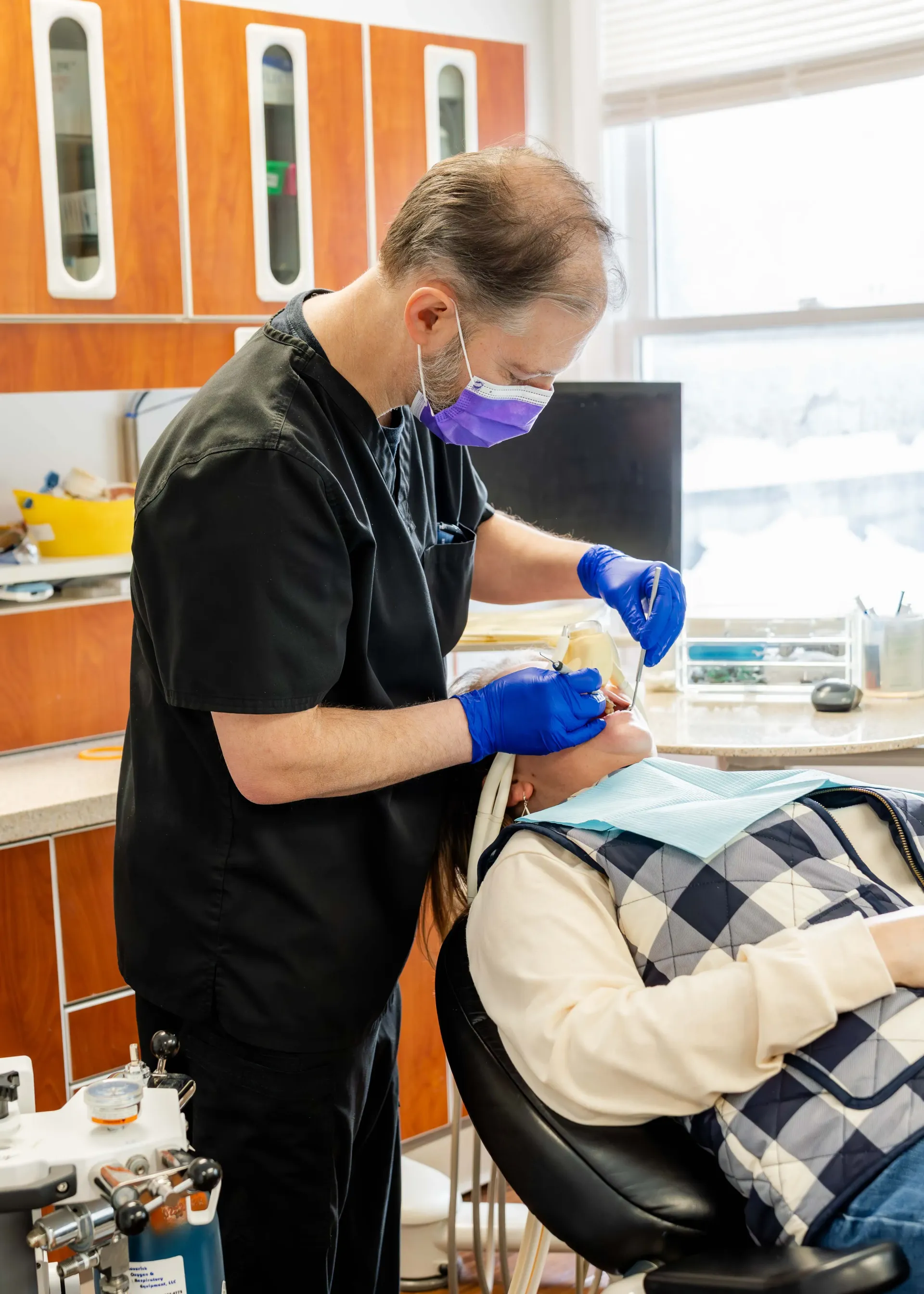 A little girl is having her teeth examined by a dentist.