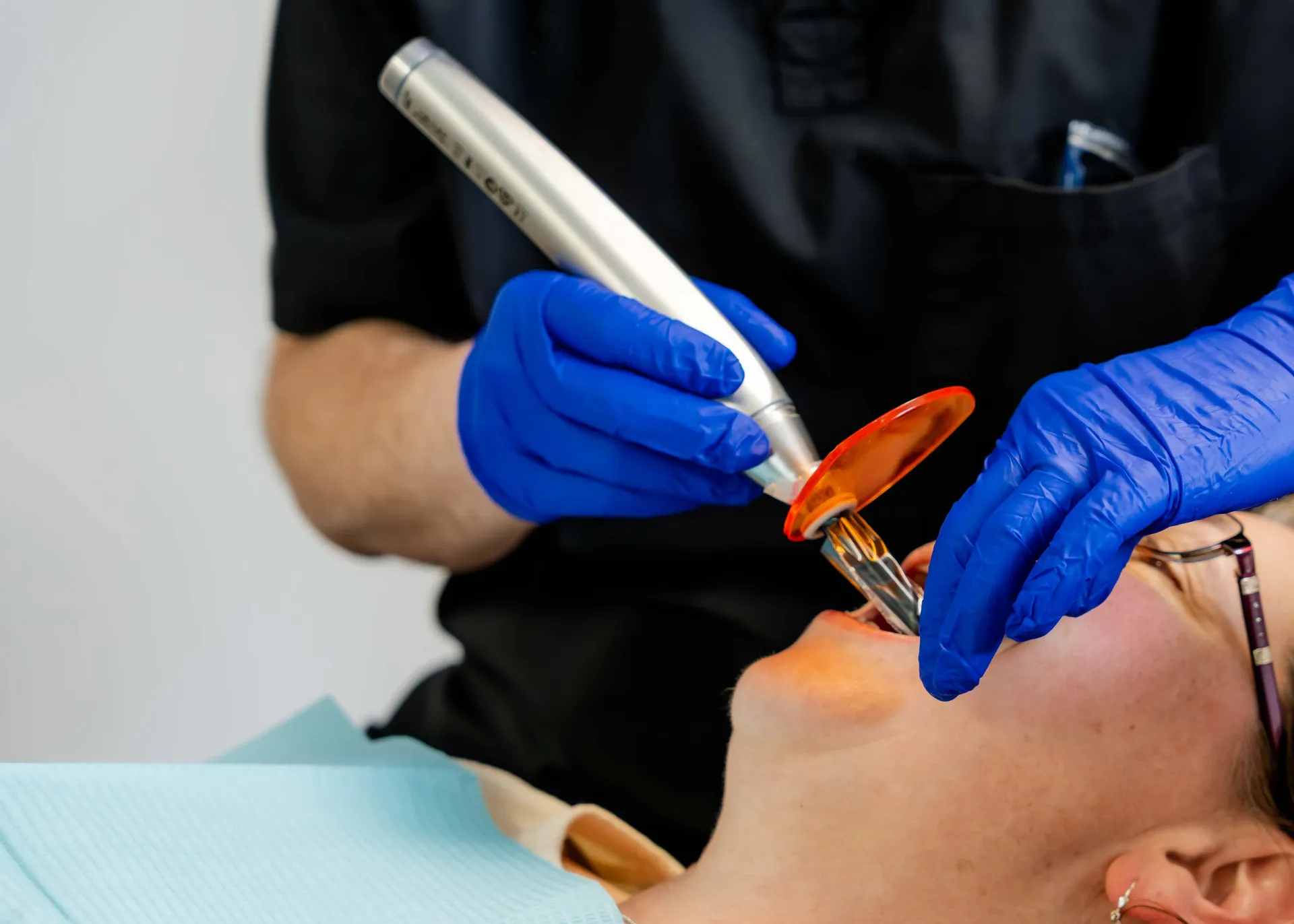 A woman is getting her teeth examined by a dentist in a dental office.