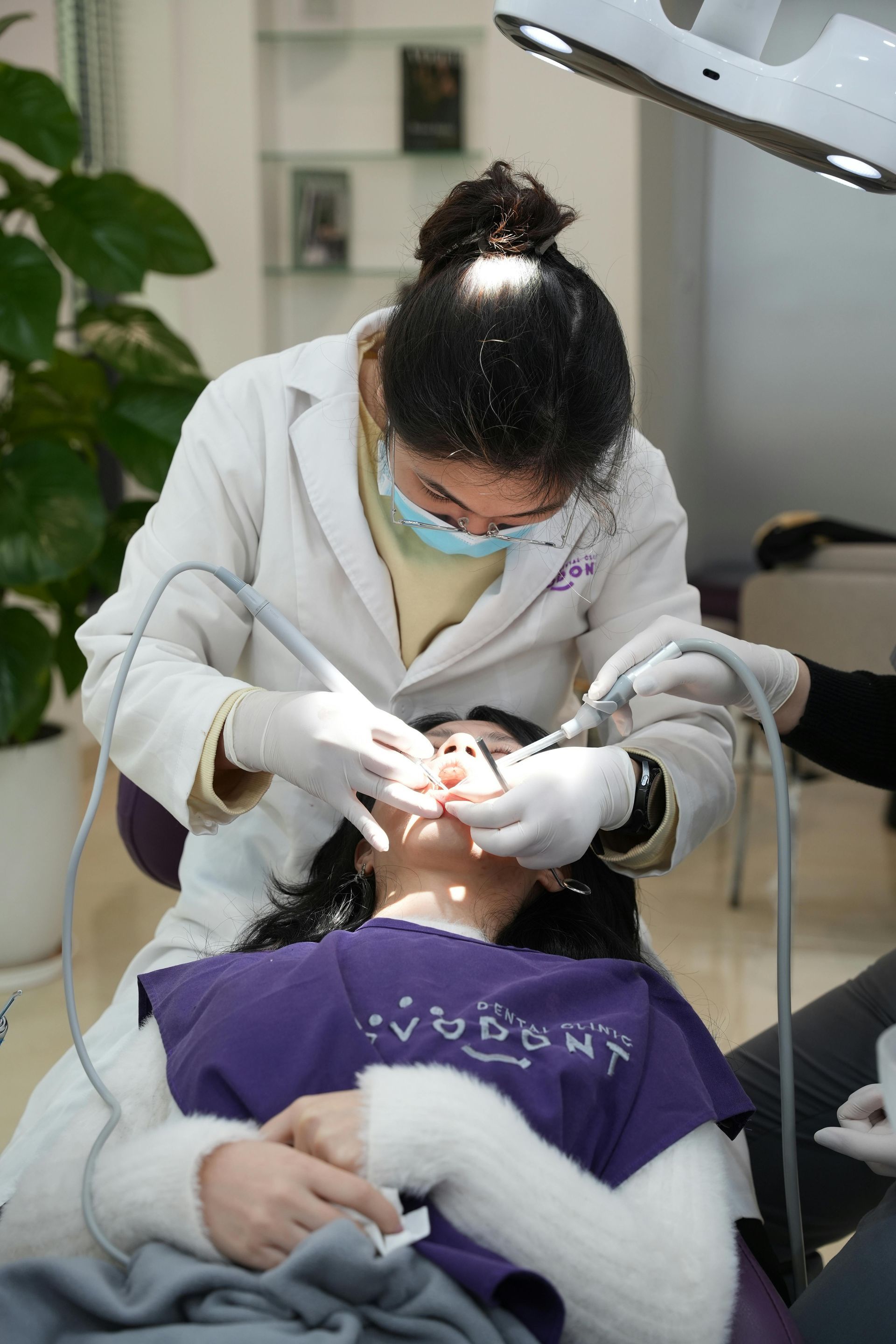 A woman is getting her teeth examined by a dentist in a dental office.