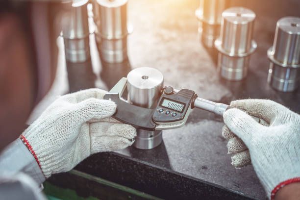 Workers use an outside micrometer to inspect products in the production line.