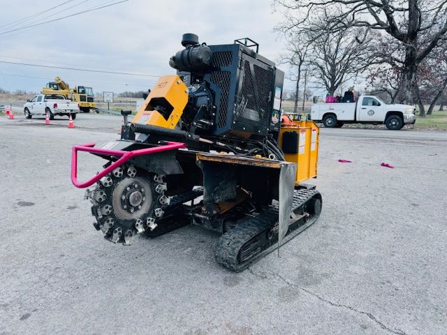 A yellow and black tractor is parked on the side of the road