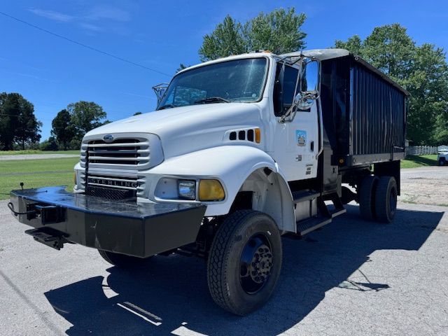 A white dump truck is parked in a parking lot.