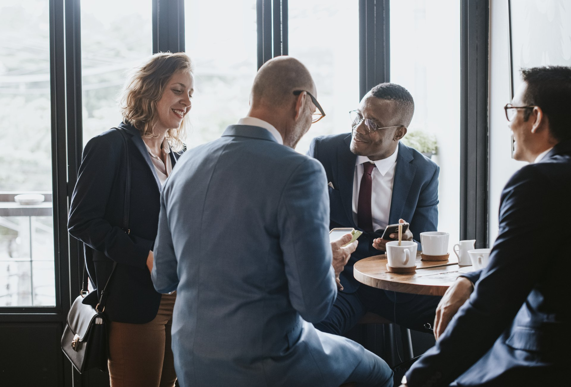 A group of business people are sitting around a table having a meeting.