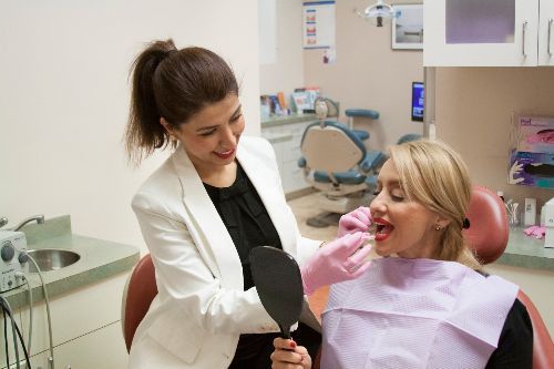 Dental assistant checking patient teeth