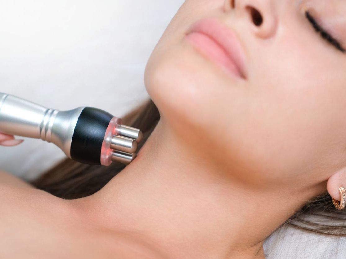 A woman is getting a facial treatment on her neck