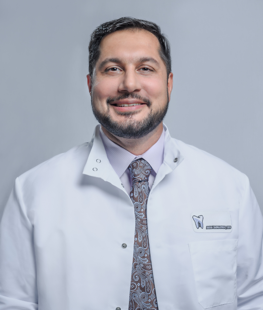 A man with a beard wearing a white coat and tie