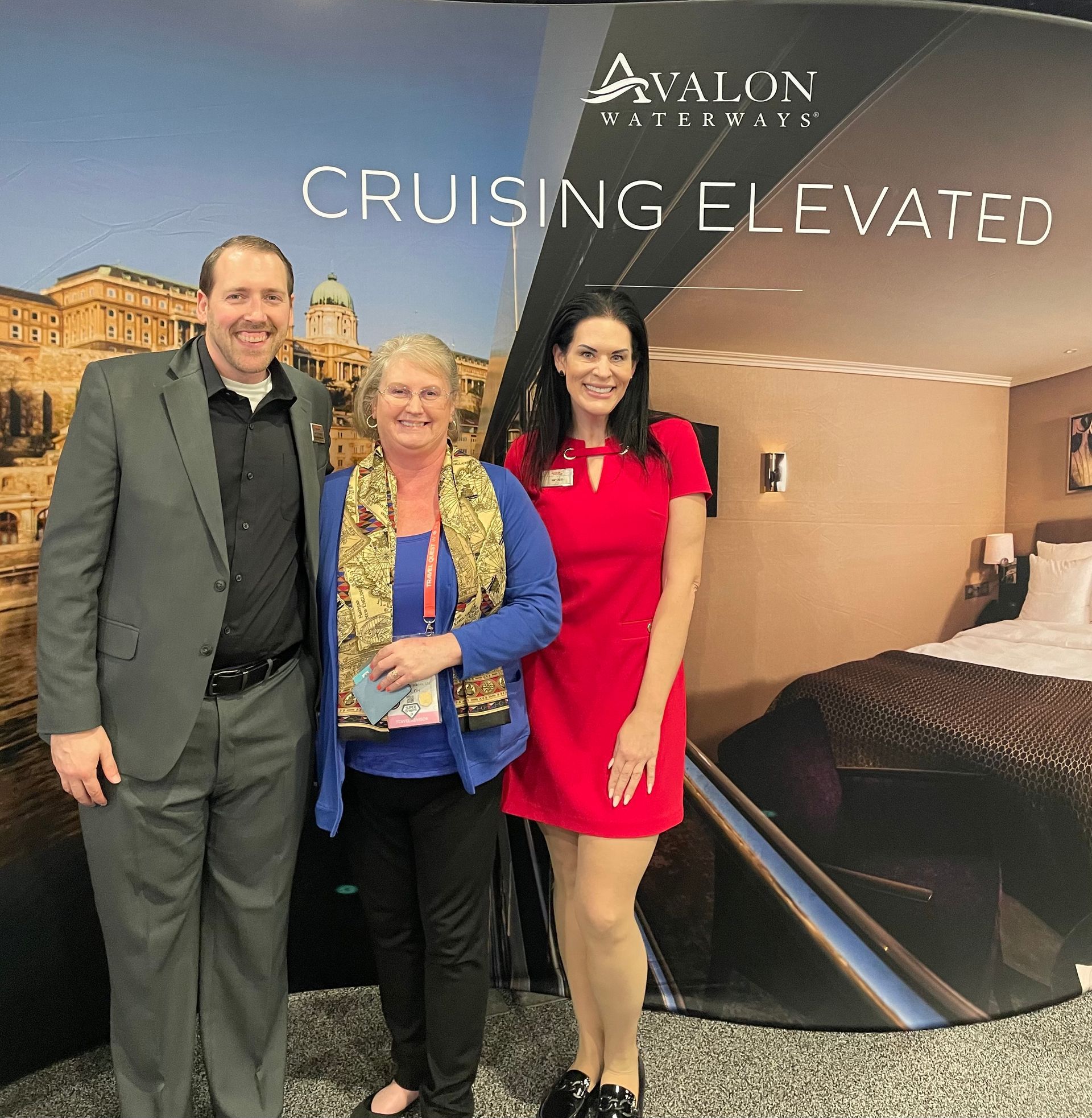 Three people standing in front of an Avalon Waterways 