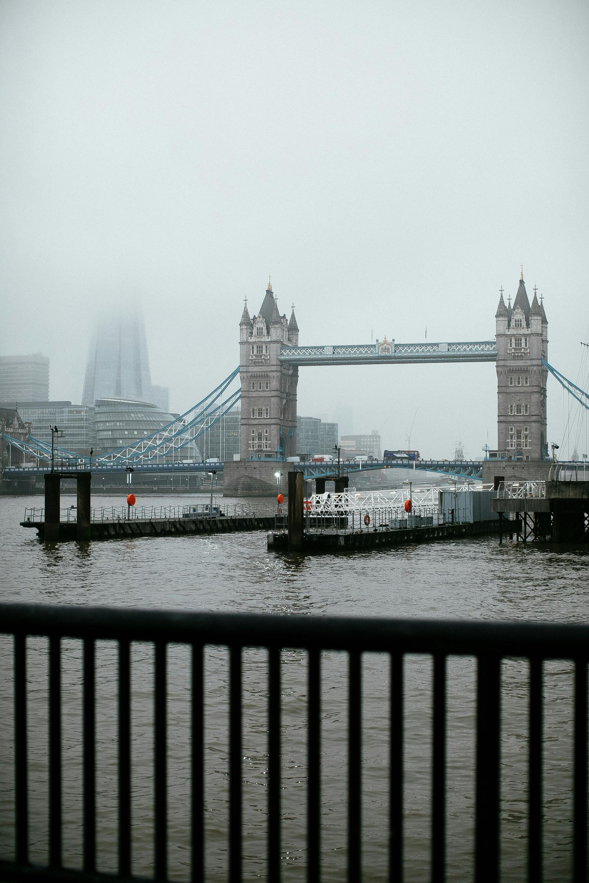 A bridge over a body of water with a fence in the foreground.