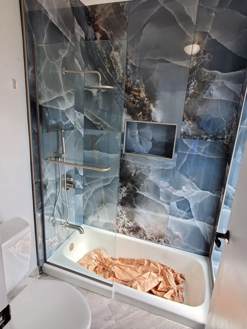 A bathroom with a bathtub , toilet and shower.