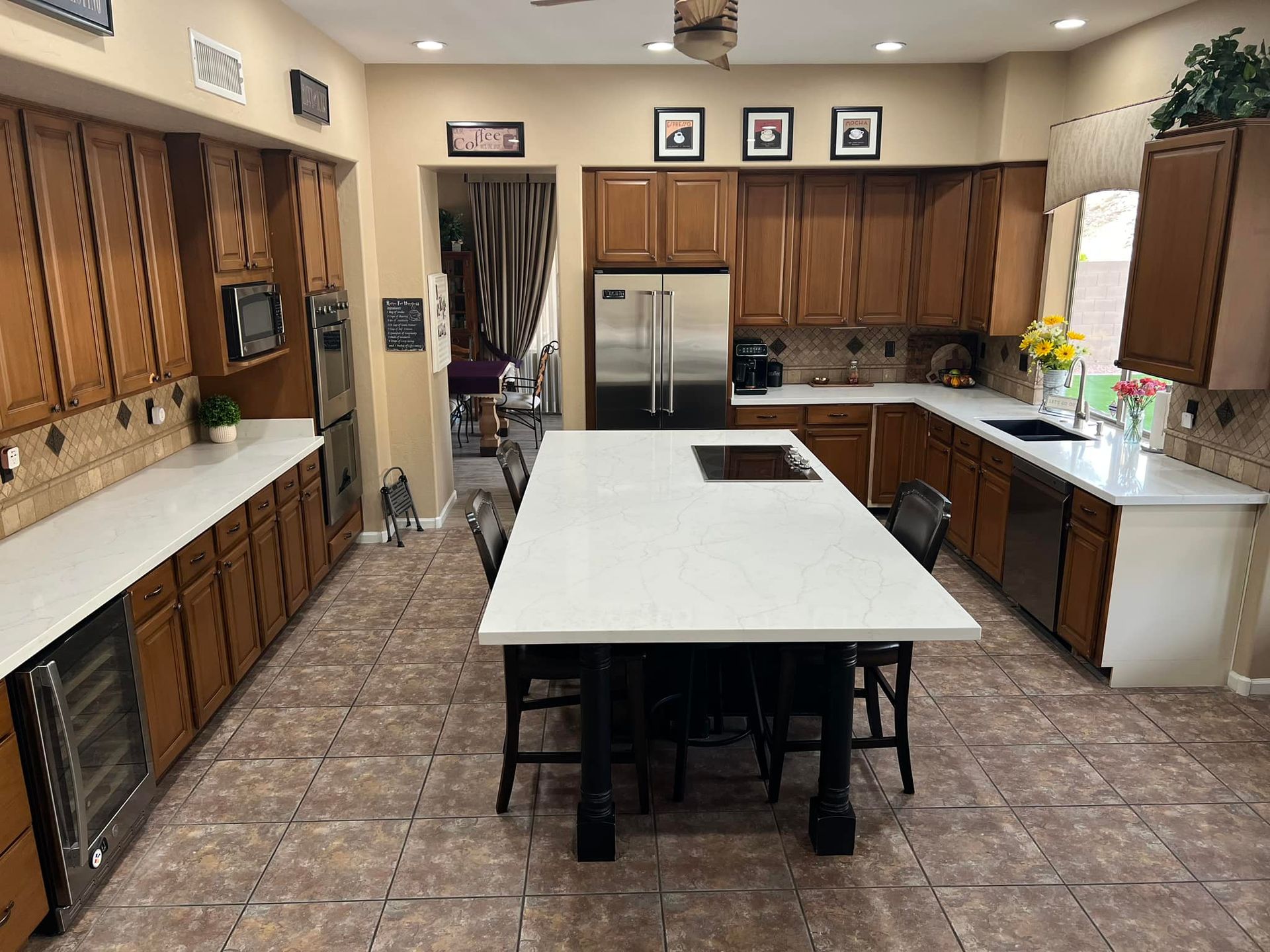 A large kitchen with wooden cabinets and white counter tops