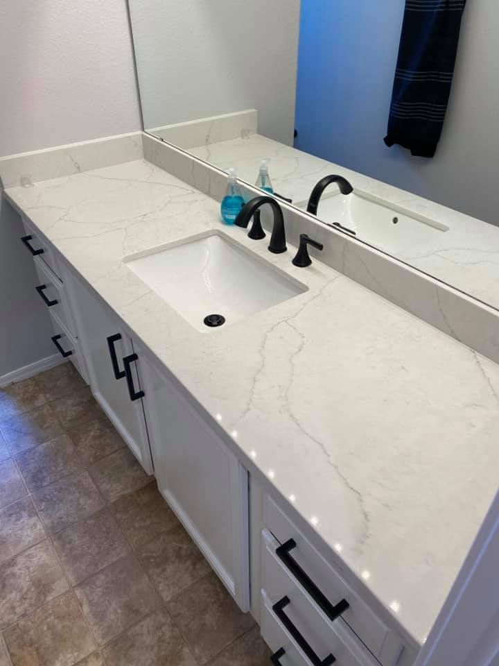 A bathroom with a sink and a large mirror.