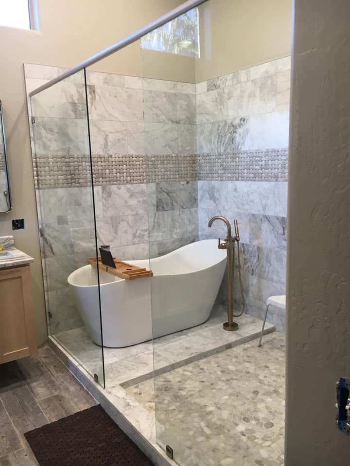A bathroom with a bathtub and a walk in shower.