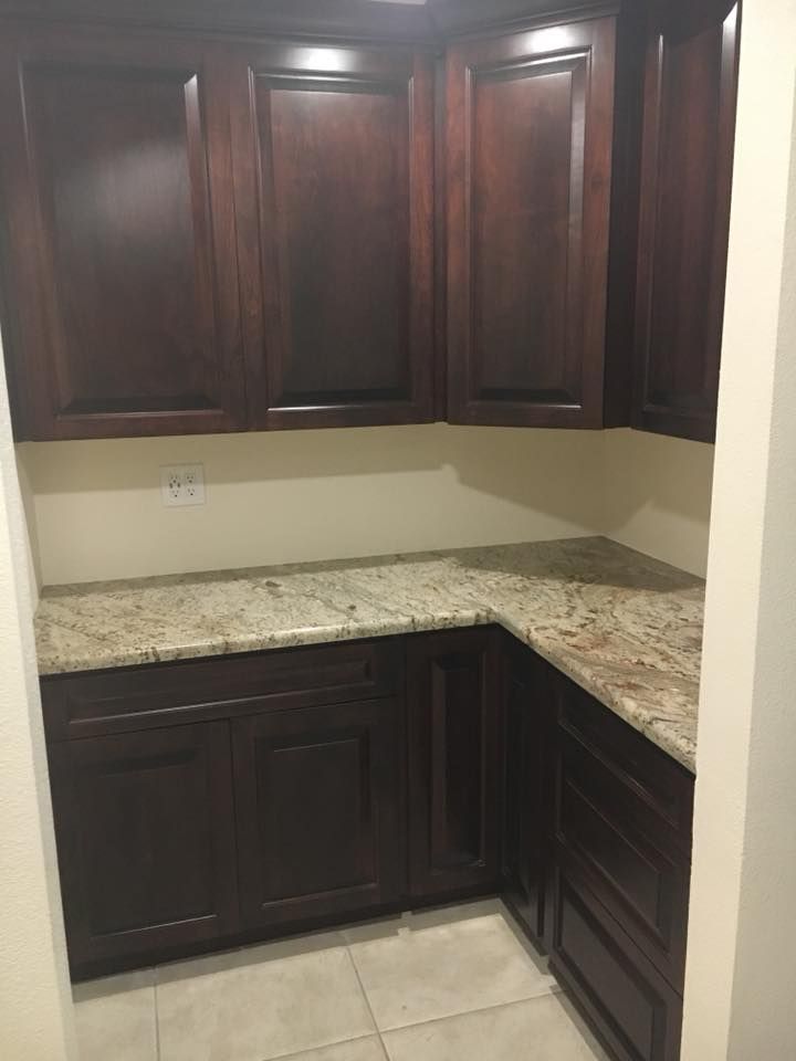 A kitchen with wooden cabinets and granite counter tops.
