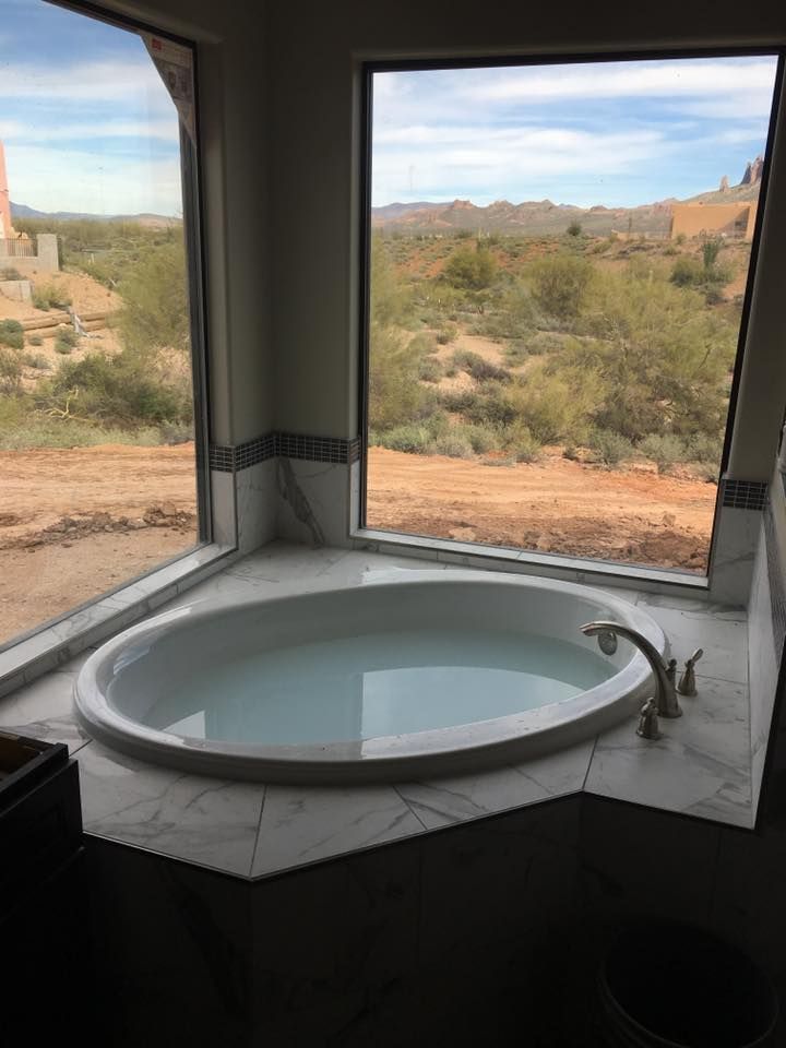 A bathtub in a bathroom with a view of the desert.