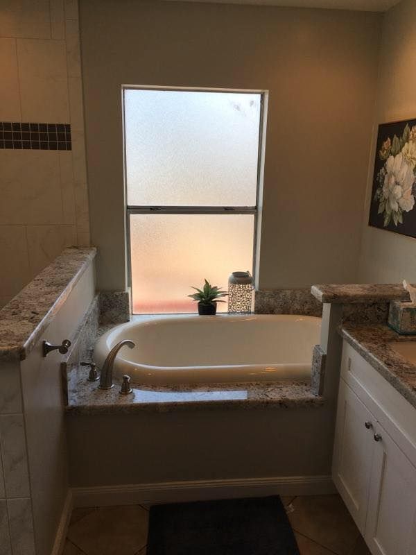 A bathroom with a bathtub and a window.